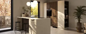 Helle, moderne Küche mit Kochinsel in Steinoptik, zwei schwarzen Barhockern und runden Pendelleuchten; schwarze Fensterrahmen mit Blick ins Grüne, Hochschrankwand in Holz und Beige mit integriertem Backofen sowie offenes Regal und Zimmerpflanze.